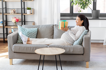 Image showing happy pregnant woman with gift box at home