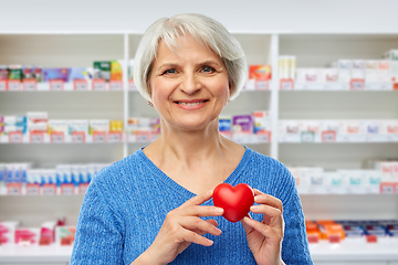 Image showing smiling senior woman with red heart