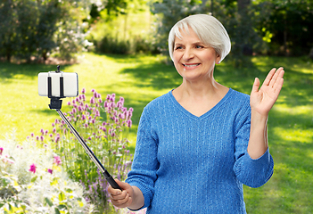 Image showing smiling senior woman taking selfie by smartphone