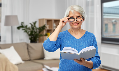 Image showing senior woman in glasses reading book