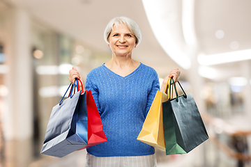 Image showing senior woman with shopping bags over grey