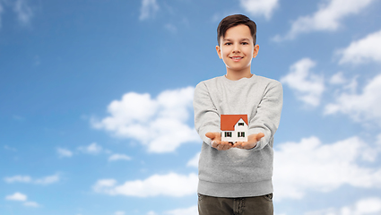 Image showing smiling boy holding house model