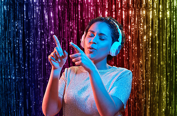 Image showing woman in headphones listening to music and dancing