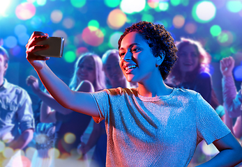 Image showing woman taking selfie with smartphone at nightclub