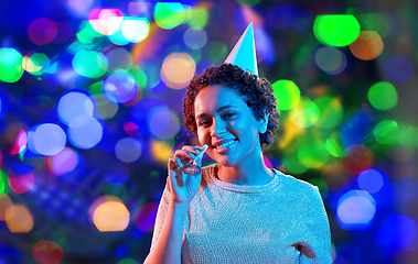 Image showing african woman in party cap with blower over black