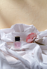 Image showing bottle of perfume and flower on white sheet