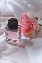 Image showing bottle of perfume and flower on white sheet