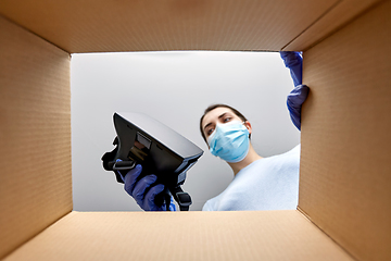 Image showing woman in mask taking vr glasses out of parcel box