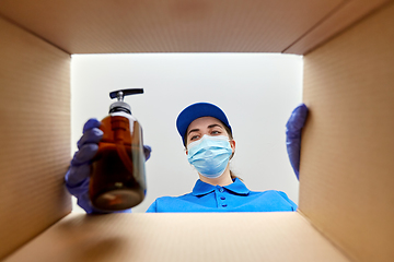 Image showing woman in mask packing parcel box with cosmetics