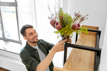 Image showing man decorating home with flowers in vase