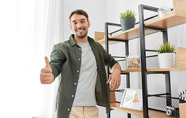 Image showing smiling man showing thumbs up at home