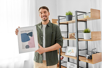 Image showing man decorating home with picture in frame