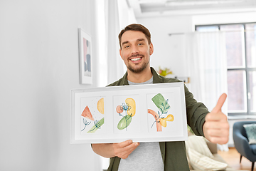 Image showing smiling man decorating home with picture in frame