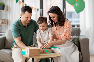 Image showing happy family opening birthday presents at home