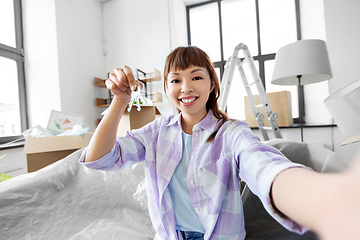 Image showing asian woman with keys taking selfie at new home