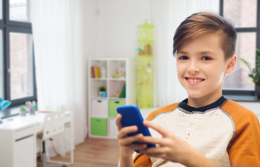 Image showing boy with smartphone texting or playing at home