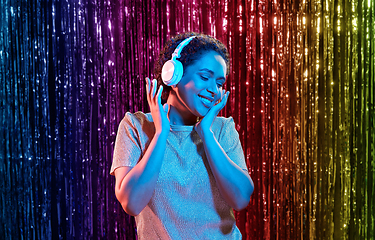 Image showing woman in headphones listening to music at party