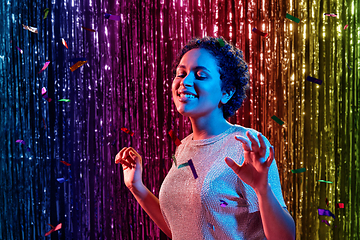 Image showing african woman under confetti at nightclub party