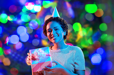 Image showing african woman in party cap with gift box on black