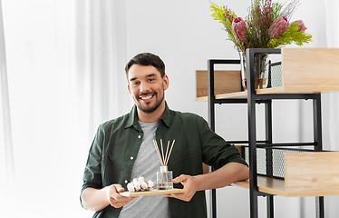 Image showing man placing aroma reed diffuser to shelf home