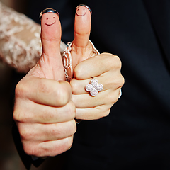 Image showing wedding rings on her fingers painted with the bride and groom