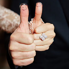 Image showing wedding rings on her fingers painted with the bride and groom