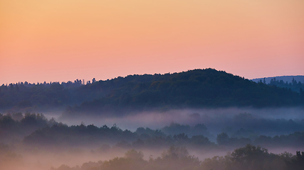 Image showing Misty morning of hilly area with ray of light.