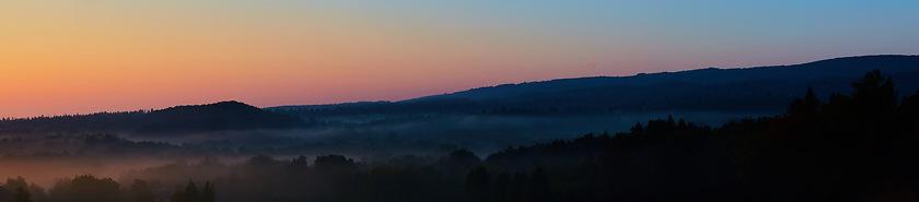 Image showing Misty morning of hilly area with ray of light.