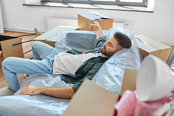 Image showing tired man with boxes moving to new home