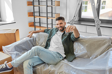 Image showing man with house keys and boxes moving to new home