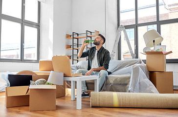 Image showing man with box of pizza and beer bottle at new home