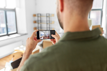 Image showing man with smartphone taking picture of new home