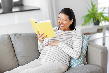 Image showing happy pregnant woman reading book at home