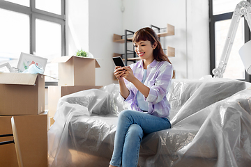 Image showing asian woman with smartphone moving into new home