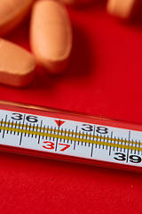 Image showing Mercury thermometer and medical pills on background