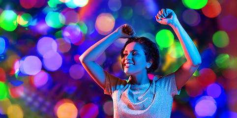 Image showing african american woman dancing over neon lights