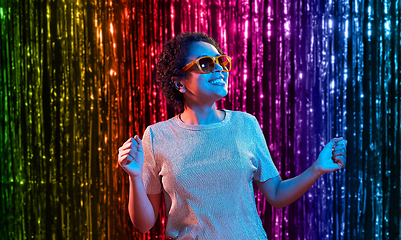 Image showing african american woman dancing over neon lights