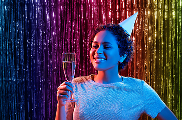 Image showing african woman in party cap with glass of champagne