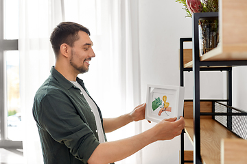 Image showing man decorating home with picture in frame