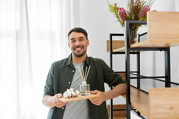 Image showing man placing aroma reed diffuser to shelf home