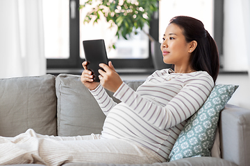 Image showing happy pregnant asian woman with tablet pc at home