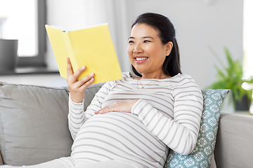 Image showing happy pregnant woman reading book at home