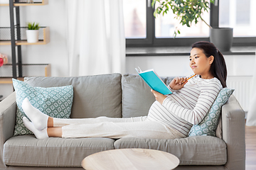 Image showing pregnant woman writing to diary at home