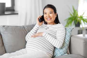 Image showing happy pregnant woman calling on smartphone at home