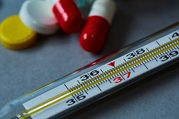 Image showing Mercury thermometer and medical pills on background