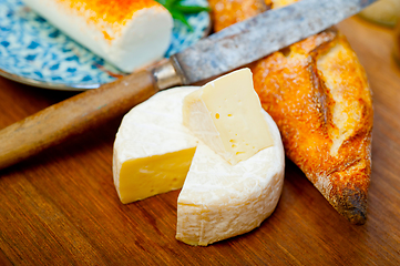 Image showing French cheese and fresh  baguette on a wood cutter