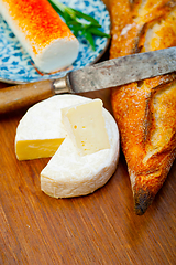 Image showing French cheese and fresh  baguette on a wood cutter