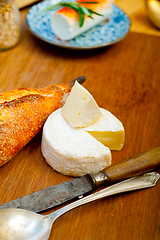 Image showing French cheese and fresh  baguette on a wood cutter