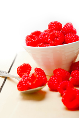 Image showing bunch of fresh raspberry on a bowl and white table