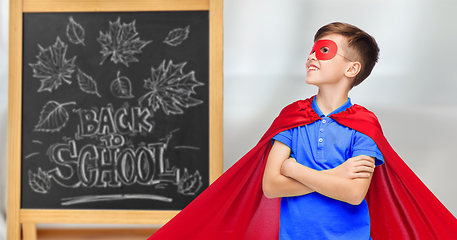 Image showing boy in super hero costume over school blackboard